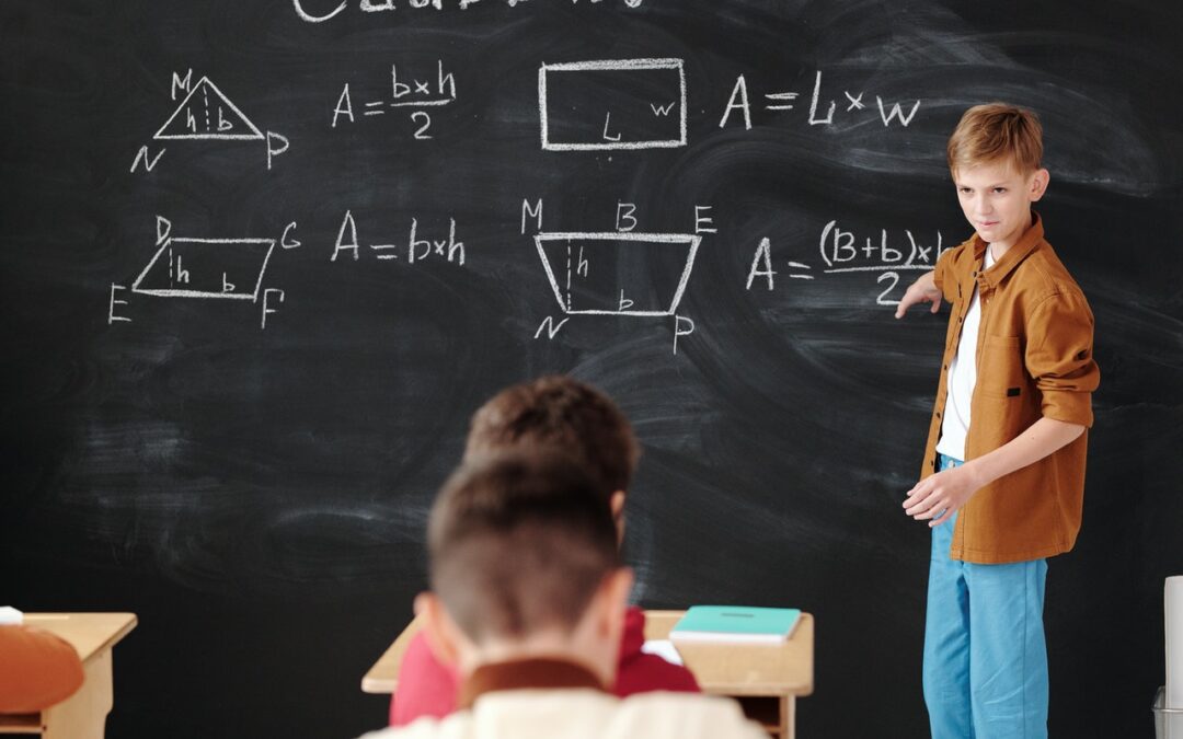 School pupil doing mathematics on a chalkboard